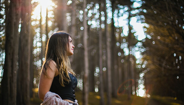 Woman walking in a forest to reduce anxiety. Image by Kitera Dent