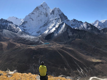 Woman looking up at mountain peak