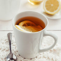 Närbild av en kopp te på ett bord, serverad i en enkel och ren miljö.