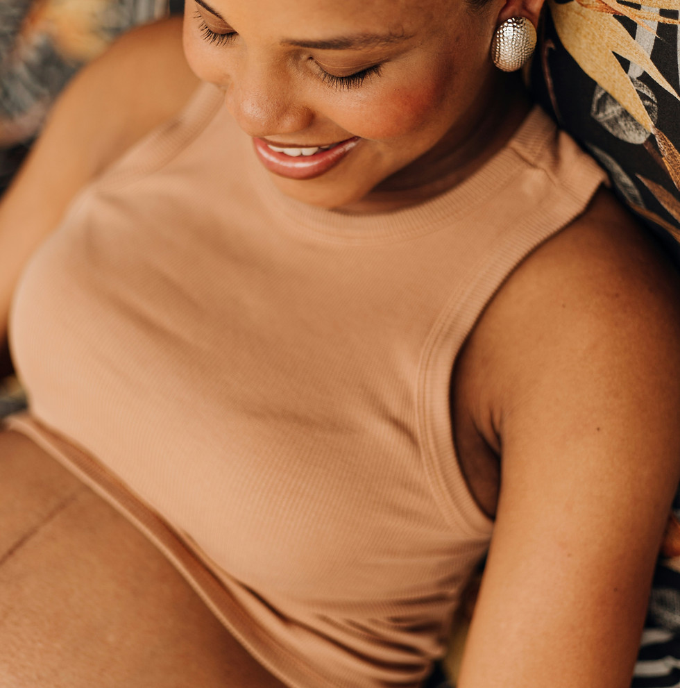 Smiling pregnant woman looking at her belly
