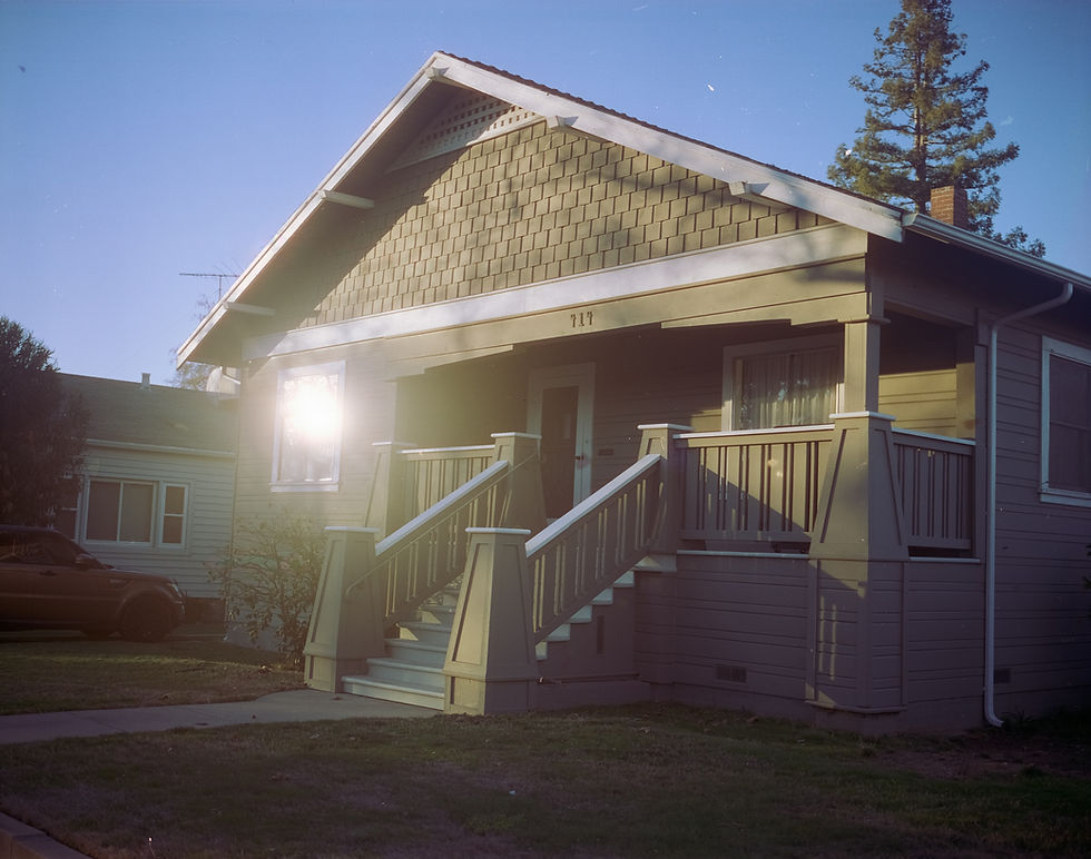 The lit front porch of a California bungalow at dusk, the kind of home where families arrange in-home care in South Los Angeles