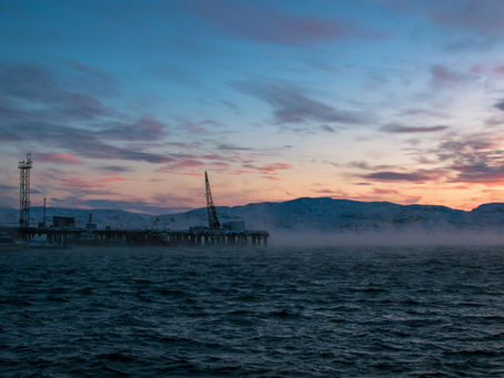Offshore oil platform silhouetted at dusk on a cold sea