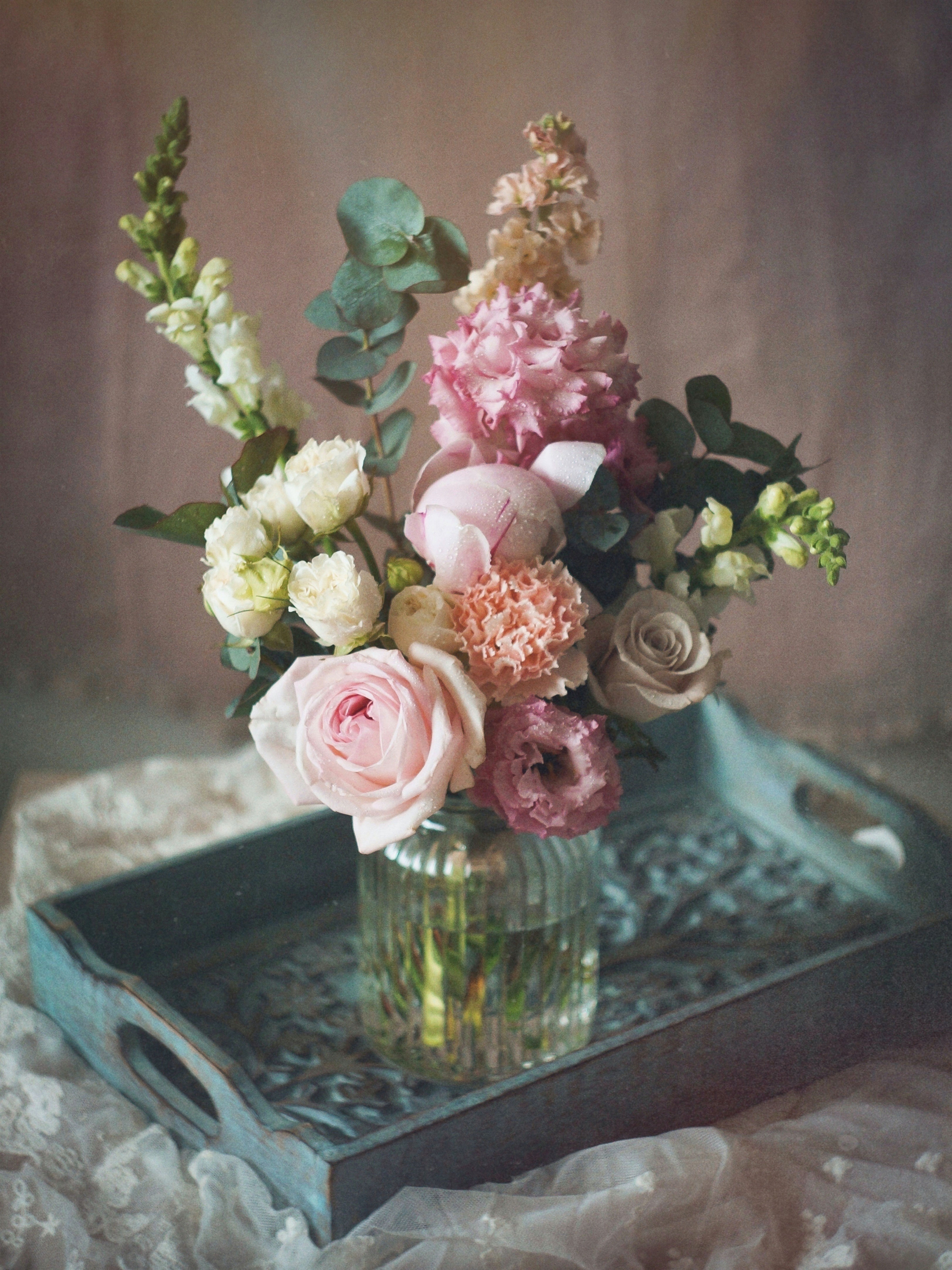 Colorful flower bouquet in vase on a decorative tray