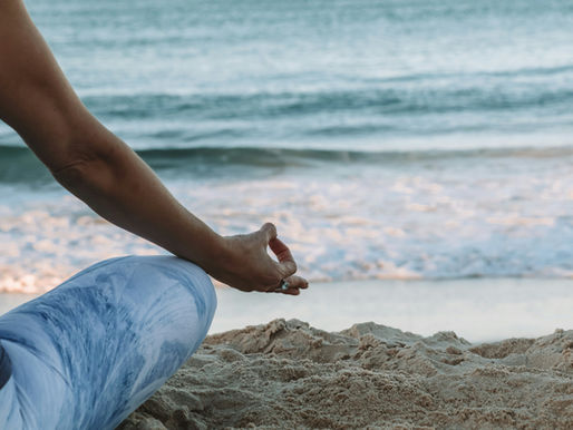 Person meditating at the beach.