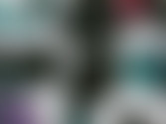 Rolled yoga mats in various colors are neatly arranged in a white cubby shelf. Bright hues of teal, black, purple, and pink dominate.