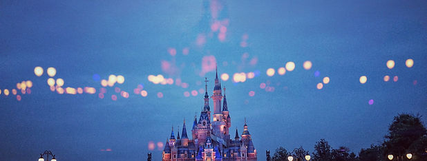 Top of Cinderella Castle at dusk with lights in the sky Image by PAN XIAOZHEN