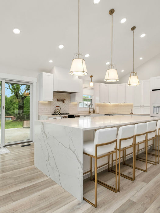 Modern kitchen remodel: white cabinets, marble island, patio view