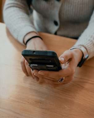 Person holding a phone while booking a free wellness business coaching connection call online.