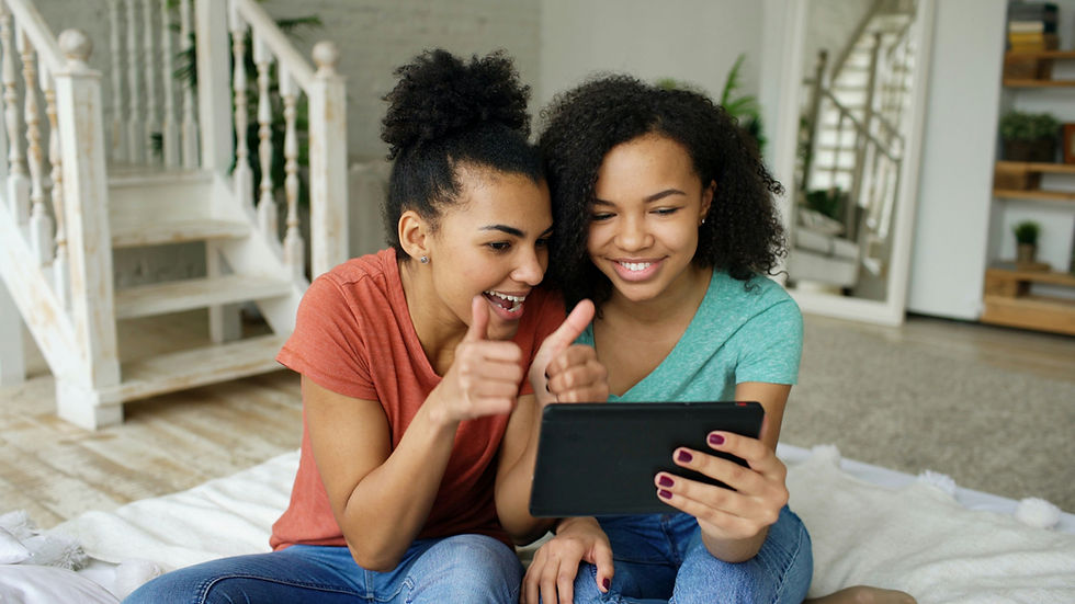 Two people smiling while looking at tablet