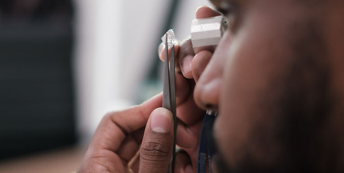 jeweler looking at a diamond with magnifying glass