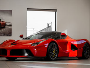 Red Ferrari in a garage with a photo of a red car on the back wall