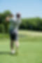 A man swings a golf club on a green field, representing Elevated Sport and Spine's focus on athletic performance.