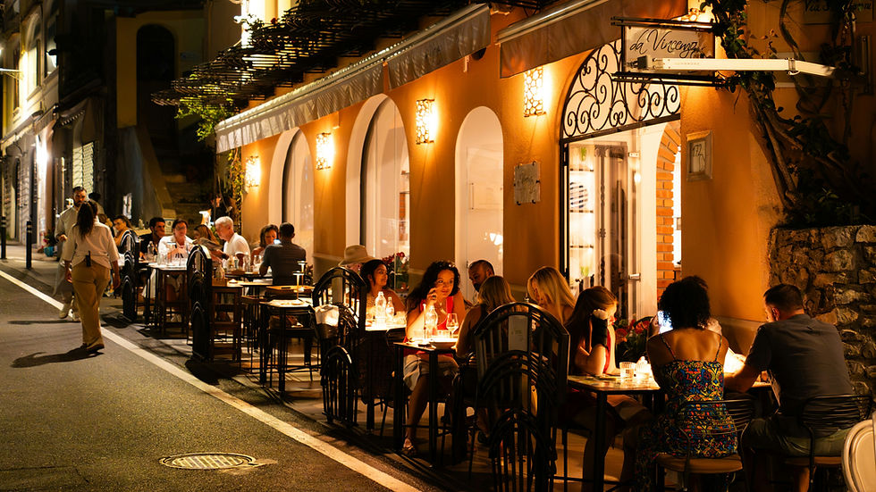 Gäste genießen Drinks in einem Restaurant mit warmer Abendstimmung und bleiben länger