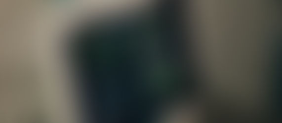 Medical monitor showing vital signs with green waveform and numbers on a black screen. White device, calm clinical setting.