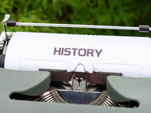 An A4 paper inserted into a typewriter reading the word History.