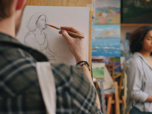 Art student sketches a seated woman in a studio, with colorful paintings behind her and a calm, focused mood.