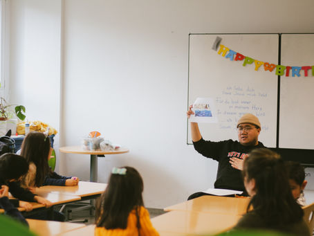 Teacher showing a piece of paper to a class of students