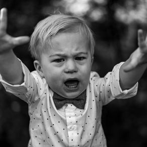 a little boy raising his arms and crying