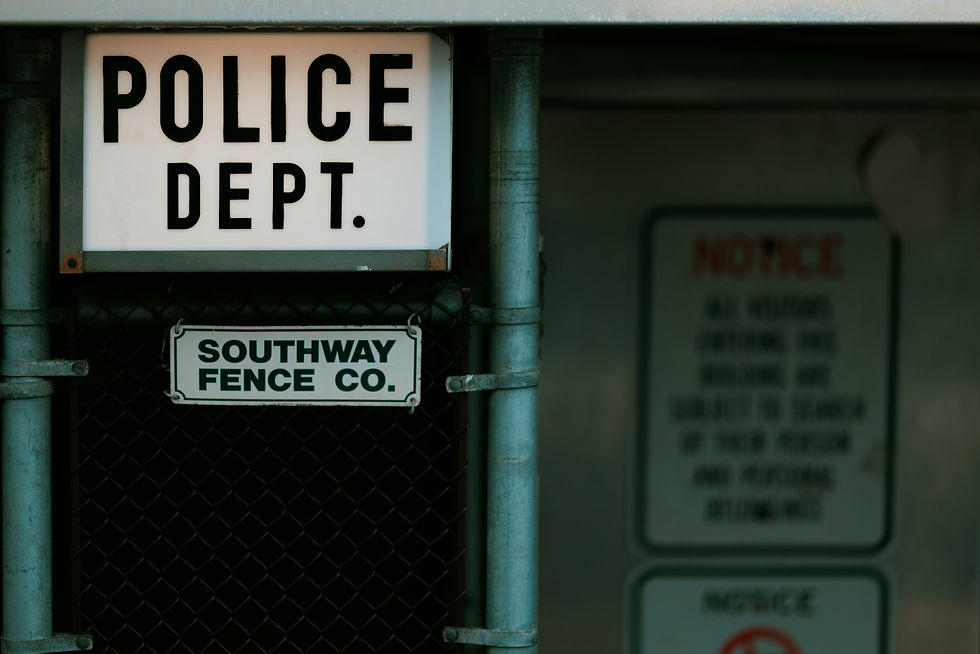 Police Department sign mounted above a Southway Fence Co. sign, symbolizing law enforcement's role in traffic safety enforcement