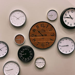 A wall with a variety of round clocks