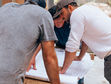 Renovation professionals reviewing kitchen plans together on a New York City job site.