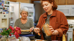 A caregiver preparing a balanced meal with an older adult