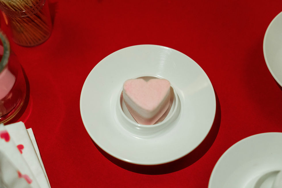 Een stuk zeep in de vorm van een hartje op een wit bord.