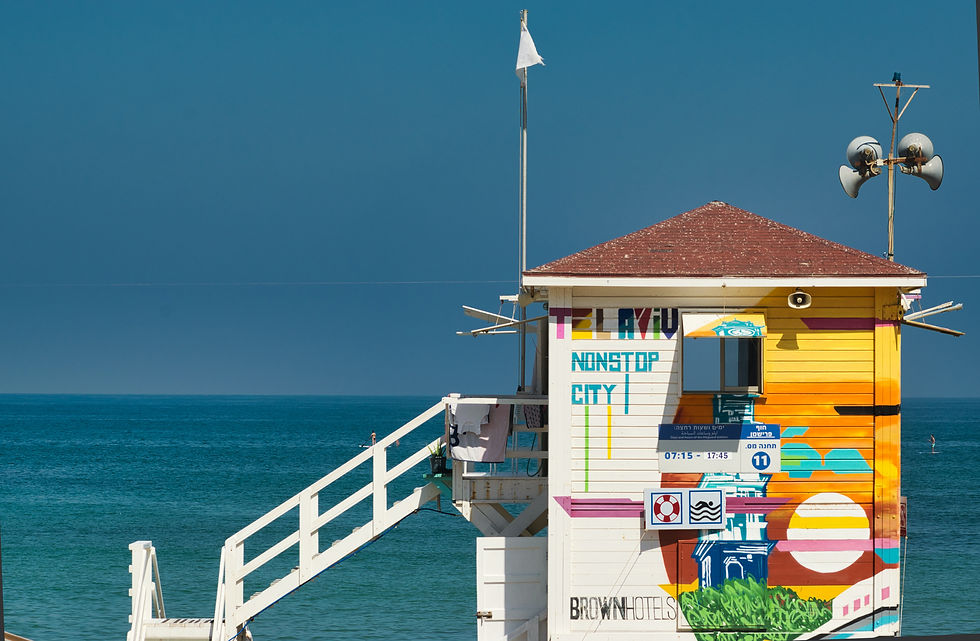 Eye-level view of a colorful street sign in Tel Aviv with Hebrew slang graffiti