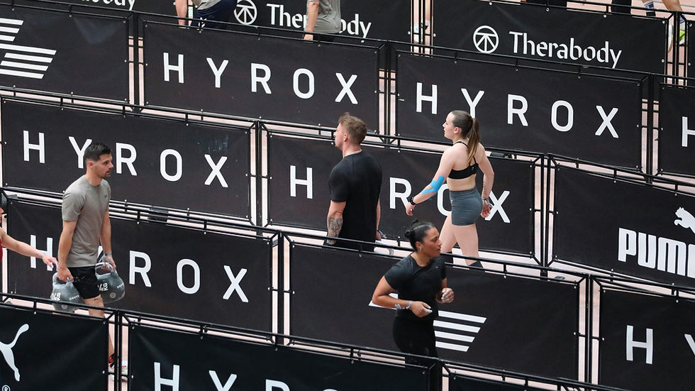 atleta realizando farmer carry en competición Hyrox – fisioterapia deportiva Madrid
