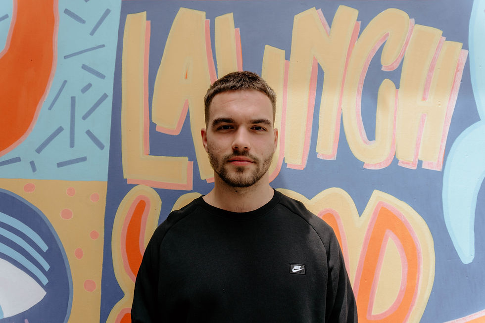 Man in black Nike shirt stands in front of colorful mural | autism therapist katy | autism therapy for adults katy, tx | autism therapy for women katy, tx | West Houston, TX | Cypress, Texas | Bridgeland, TX