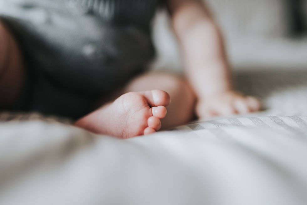 Close-up of sleeping baby feet on a white surface