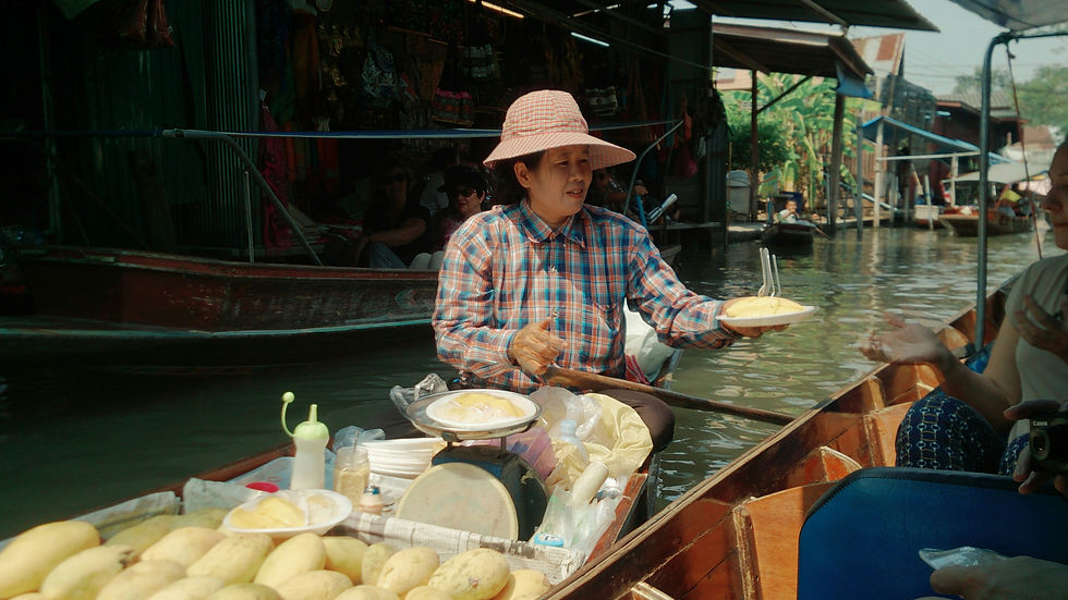 Vendor selling mango sticky rice from a boat at Damnoen Saduak Floating Market near Bangkok
