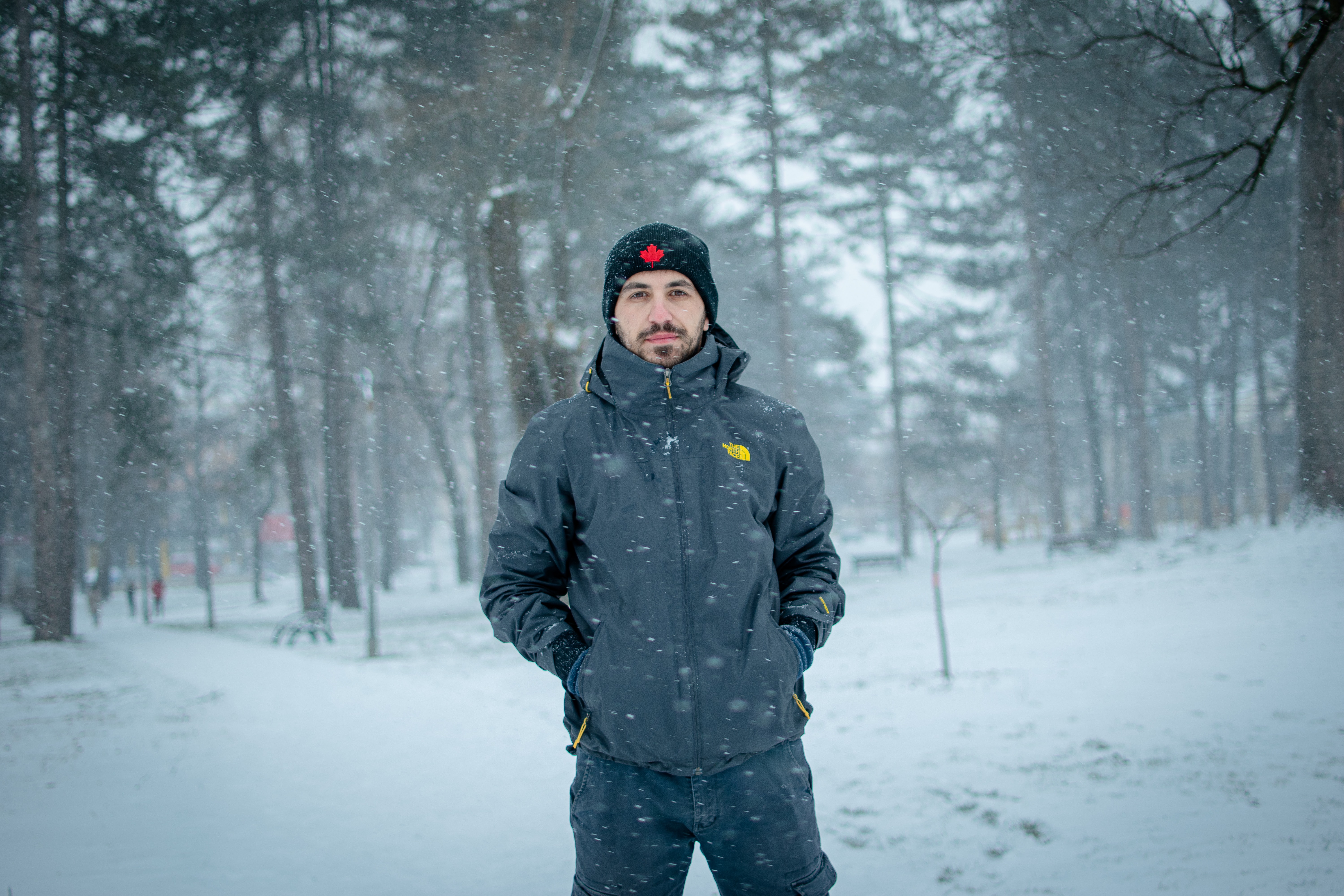 Man in winter jacket standing in a snowy forest