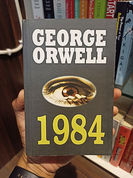 a person holding the book "1984"
