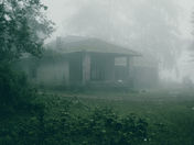 A fog-covered house at dawn, symbolizing hidden truths waiting to surface — inspired by The Legend of Sleepy Hollow.