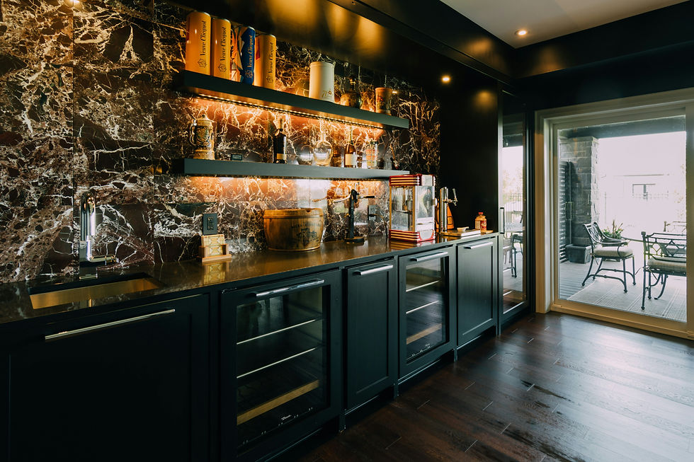 Modern bar area with dark cabinets, marble backsplash, glass shelves with bottles, and a popcorn maker. Patio visible through glass door.