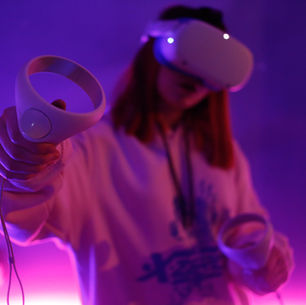 Jeune femme portant un casque de réalité virtuelle Meta Quest dans une pièce à lumière violette, tenant un contrôleur VR en avant-plan pour une immersion totale.