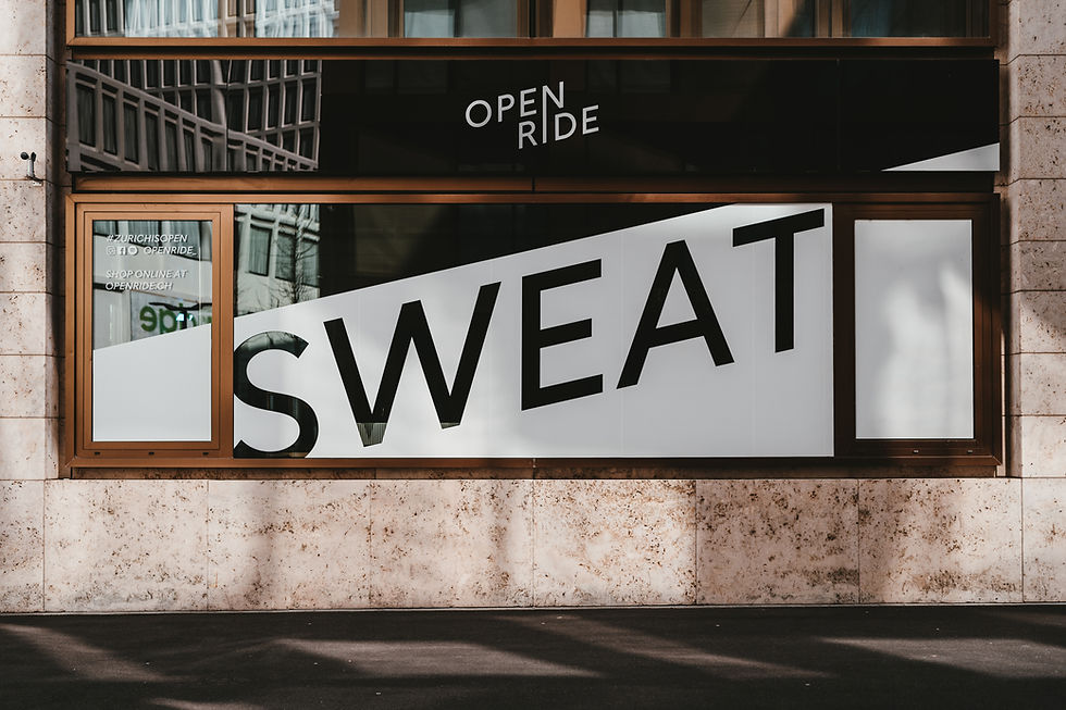 window with a sign that says 'OPEN RIDE' above and 'SWEAT' in big letters below