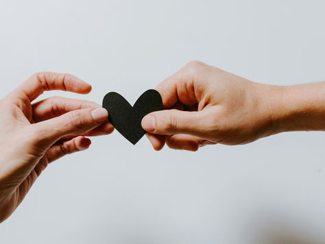 Two hands holding a paper heart