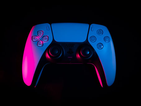 Gaming console controller, lit with blue and pink