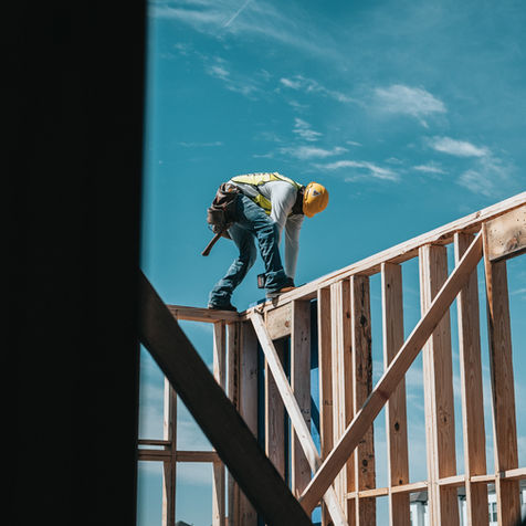 Construction worker building a wooden house frame