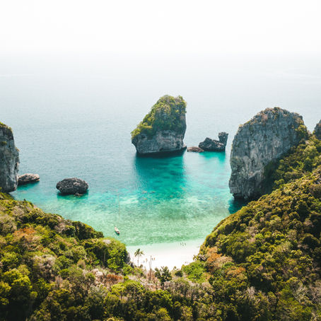 Baia paradisiaca in Thailandia con spiaggia bianca, mare cristallino e vegetazione tropicale lussureggiante – meta ideale per un viaggio di nozze a gennaio.