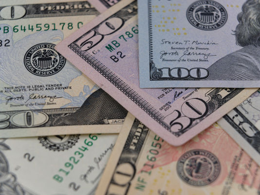 Close-up of assorted U.S. dollar bills in various denominations, overlapping each other. Visible signatures and Federal Reserve seal.