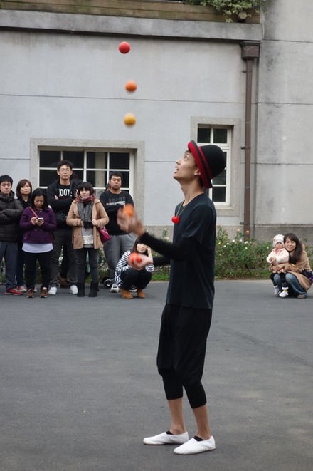Juggler performing with mini basketballs during an outdoor sports-themed show.