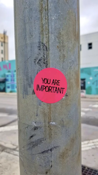 Pinker Aufkleber auf einer Straßenlaterne mit der Aufschrift "YOU ARE IMPORTANT"