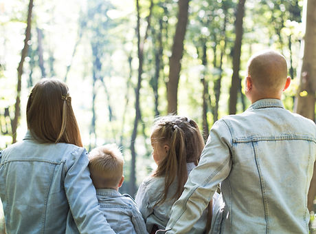 image d'une famille (des parents et deux enfants) qui sont assis dans une forêt