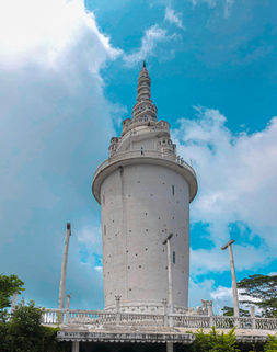 White tower against blue sky and clouds, architectural landmark, friendly tour driver