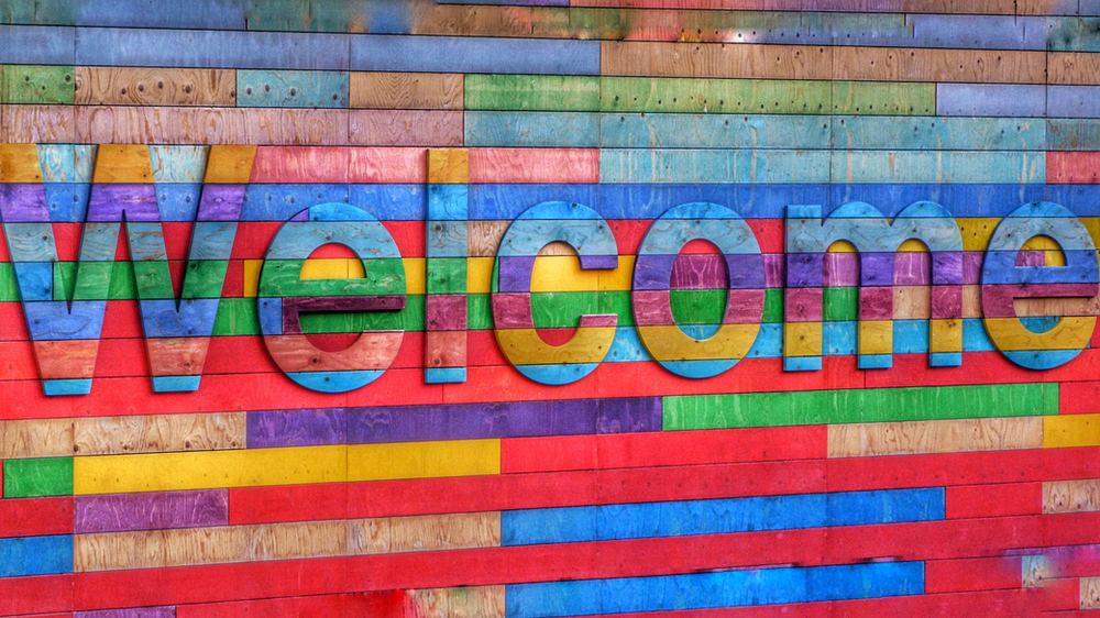 A colourful wooden sign says 'Welcome'