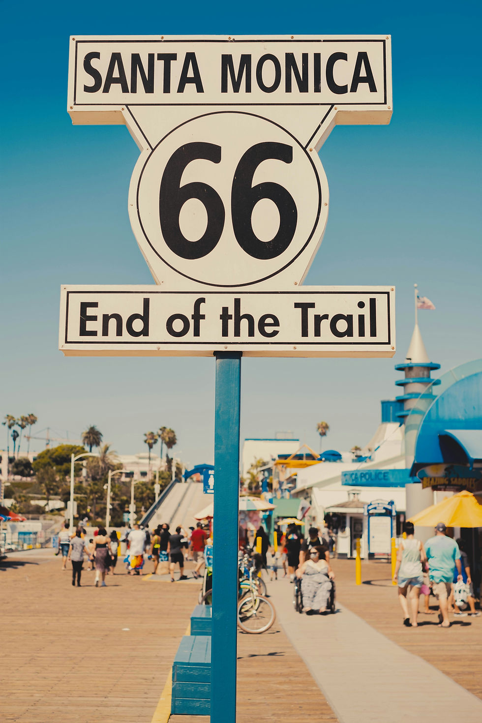 The "End of the Trail" sign stands at the Santa Monica Pier on a brilliant afternoon, 2,448 miles and a lifetime of road behind it. Photo by Kevin West on Unsplash