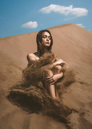 A woman sitting in the desert sand